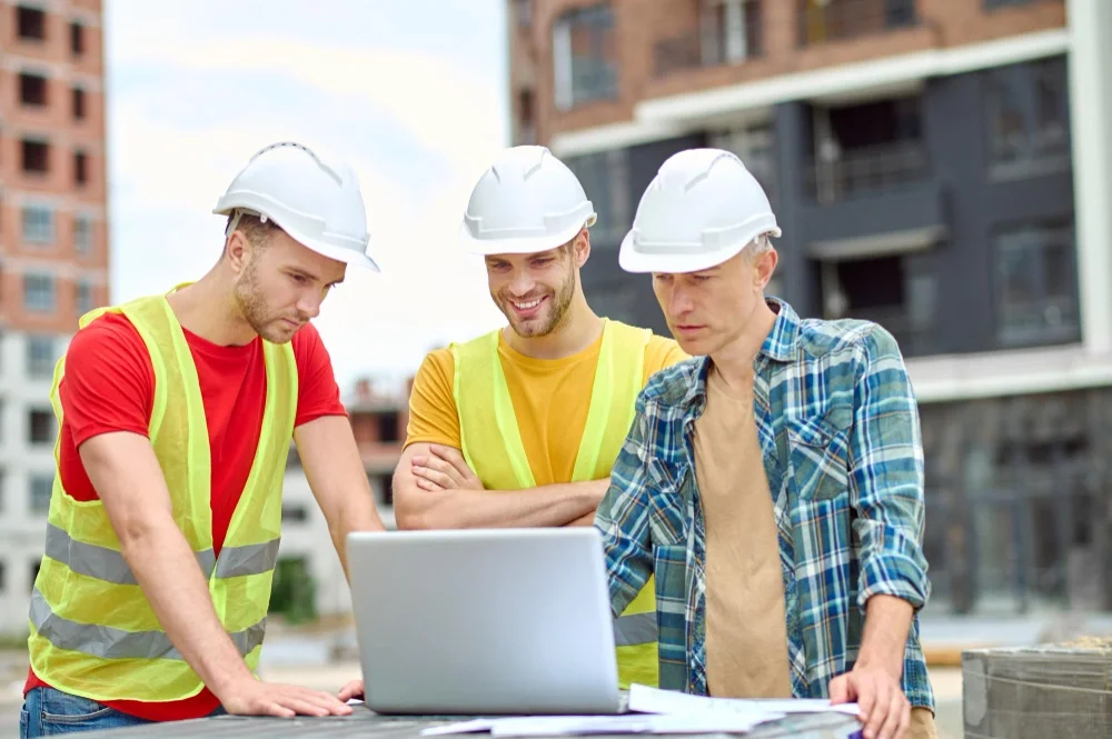 Engineers wearing helmets reviewing construction project at site, representing digital marketing for construction companies